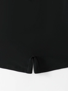 Vista macro del tessuto nero del costume con cuciture rifinite e un piccolo spacco laterale