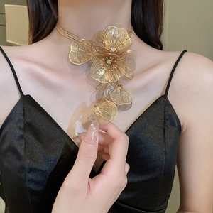 Close-up of golden hollow flower necklace with tassel design and sparkling rhinestones