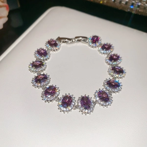Macro shot of silver-toned bracelet with purple oval stones and zircon halo setting
