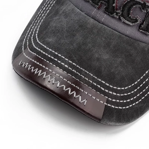 Detail of vintage grey baseball cap featuring leather edge trim and contrast stitching