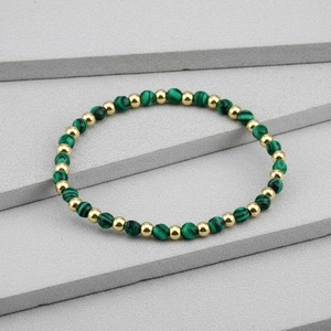Detail view of 4mm green amazonite faceted beads and gold plated metal beads on a bracelet