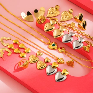 Golden and silver heart jewelry set featuring necklaces and earrings on pink steps