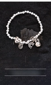 Detailed view of silver-plated copper bead bracelet with heart and rabbit charms