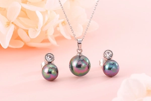 Detail of silver pearl necklace and stud earrings set with iridescent rainbow shell beads