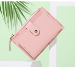 Dettaglio del portafoglio in pelle PU rosa con cerniera dorata e bottone decorativo