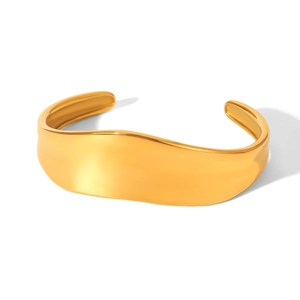 Macro detail of wave shaped 18K gold plated stainless steel cuff with polished finish