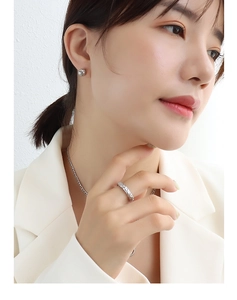 Gros plan de boucles d'oreilles boules argentées et bijoux assortis sur modèle