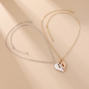 Detail of angel wing heart pendants with magnetic connection on gold and silver chains