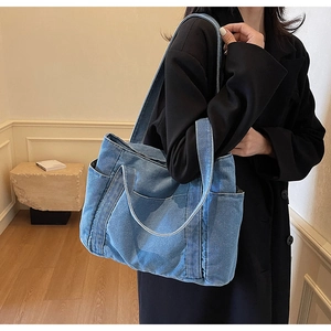 Detail of blue denim tote bag texture and large capacity style on female model