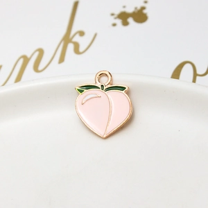 Macro shot of pink peach alloy pendant with green leaf and golden metal border