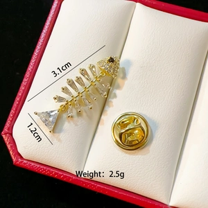 Detailed view of fishbone brooch with gold finish, cubic zirconia and size dimensions
