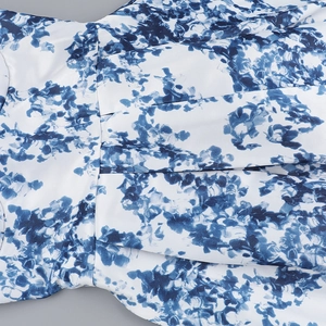Vue macro détaillée du tissu à imprimé floral blanc et bleu avec plis et coutures