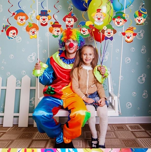 Clown theme carnival party decorations featuring colorful hanging swirls and balloons