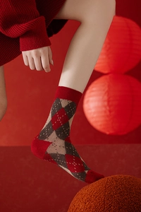 Détail de chaussettes en laine à motif argyle rouge, marron et beige avec bords côtelés