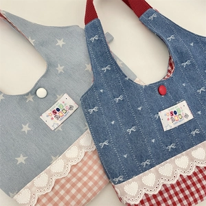 Detail of sweet lace-trimmed denim bib with patchwork stars and bow patterns