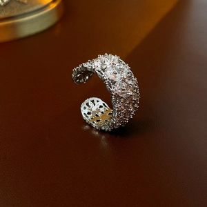 Gros plan d'une bague large argentée sertie de zircons sur cuir marron