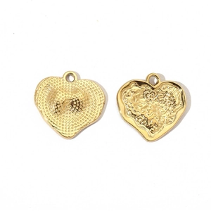 Detailed view of golden heart pendant with wave texture and letter Z engraving