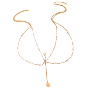 Detail of gold body chain with pink faux pearls and orange teardrop stone pendant