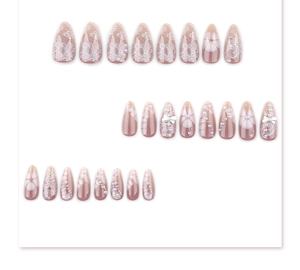 Détail de faux ongles amande roses avec motifs dentelle blanche, perles et nœuds