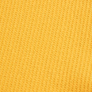 Macro texture of bright yellow waffle knit fabric for high-quality men's polo shirts