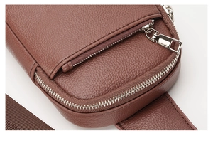Close-up of brown litchi pattern leather sling bag with premium silver metal zipper