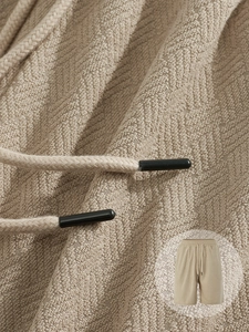 Detail of khaki waffle knit fabric texture and drawstring on men's casual shorts