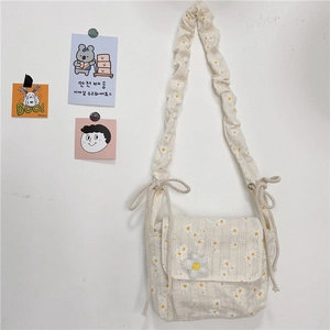 Daisy print canvas crossbody bag with ruffled strap and floral flap closure