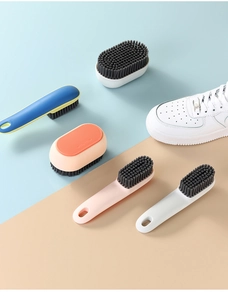 Close-up of long-handled and oval shoe cleaning brushes in multiple colors on a dual-tone background
