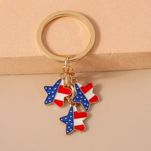 Close-up of golden keychain with red and blue star charms featuring enamel flag patterns