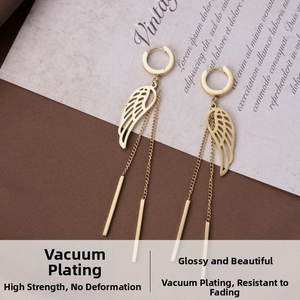 Close-up of gold stainless steel earrings with hollow wing charms and long tassel chain detail