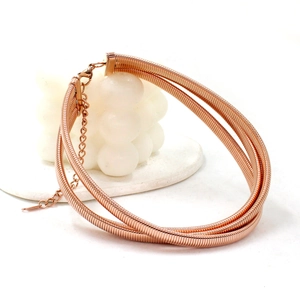 Macro detail of rose gold triple-layer coiled choker with spring texture and lobster clasp
