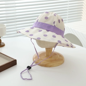 Detail of white sun hat with purple dots and adjustable chin strap for girls