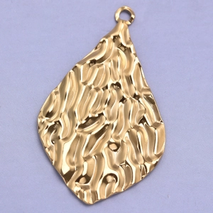 Macro shot of 304 stainless steel golden oval pendant with hammered texture detail
