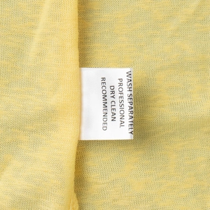 Close-up of knit fabric texture with a white care label showing laundry instructions