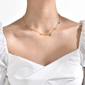 Close-up of a gold stainless steel necklace with colorful zircon gemstones on a model