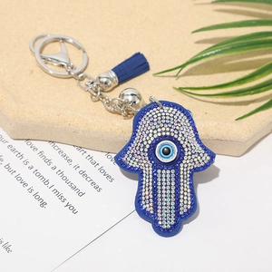 Detailed view of Hamsa Evil Eye keychain with blue rhinestones and silk tassel decor