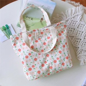 Gros plan détaillé du sac en coton fleuri avec étiquette Simple Wish sur bois blanc