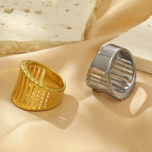 Close-up of 18K gold and silver hollowed-out stainless steel rings on luxury silk
