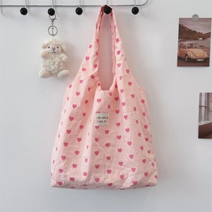 Close-up of pink heart pattern canvas tote bag with woven label and sheep charm