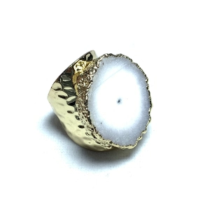 Detalle de anillo chapado en oro 14K con cristal blanco y acabado de metal martillado