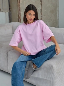 Dettaglio della maglietta rosa in cotone oversize con spalle scese e vestibilità ampia