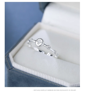 Macro shot of silver cross ring with cubic zirconia stones on velvet box padding