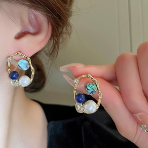Detail of vintage flower earrings with pearls and lapis lazuli in gold plated frame