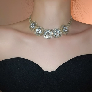 Detail view of a luxury gold choker featuring five large round crystals and micro-pave diamonds