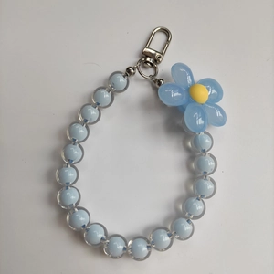 Detail of blue candy bead phone strap with clear flower charm and silver metal clasp