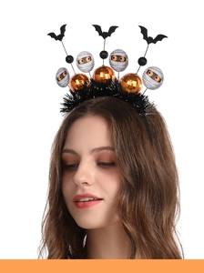 Detail of Halloween headband featuring black bats, orange sequins and mummy balls with feathers