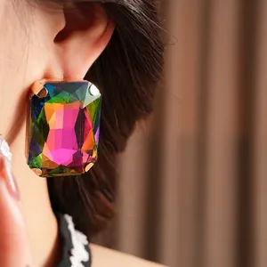 Vintage rectangular rainbow rhinestone earrings with multi-prong setting on a model