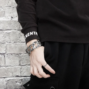 Close-up of polished silver stainless steel cuban curb chain bracelet on male wrist