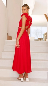 Dettaglio di un abito lungo rosso in chiffon con elegante design incrociato sulla schiena