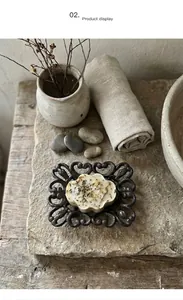 Detail of cloud-shaped herbal soap with dried flowers on a vintage heart cast iron soap dish